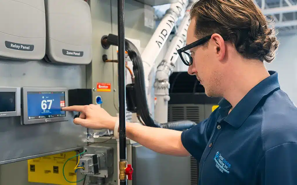 Central Cooling & Heating employee programming a thermostat